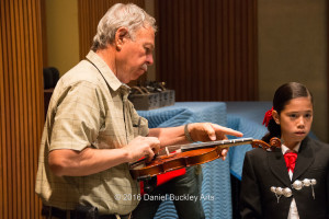 Alfredo Valenzuela tunes the violins.