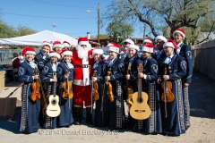 Members of Mariachi Aztlan help Santa bring cheer to families in Barrio Anita at Christmas time.